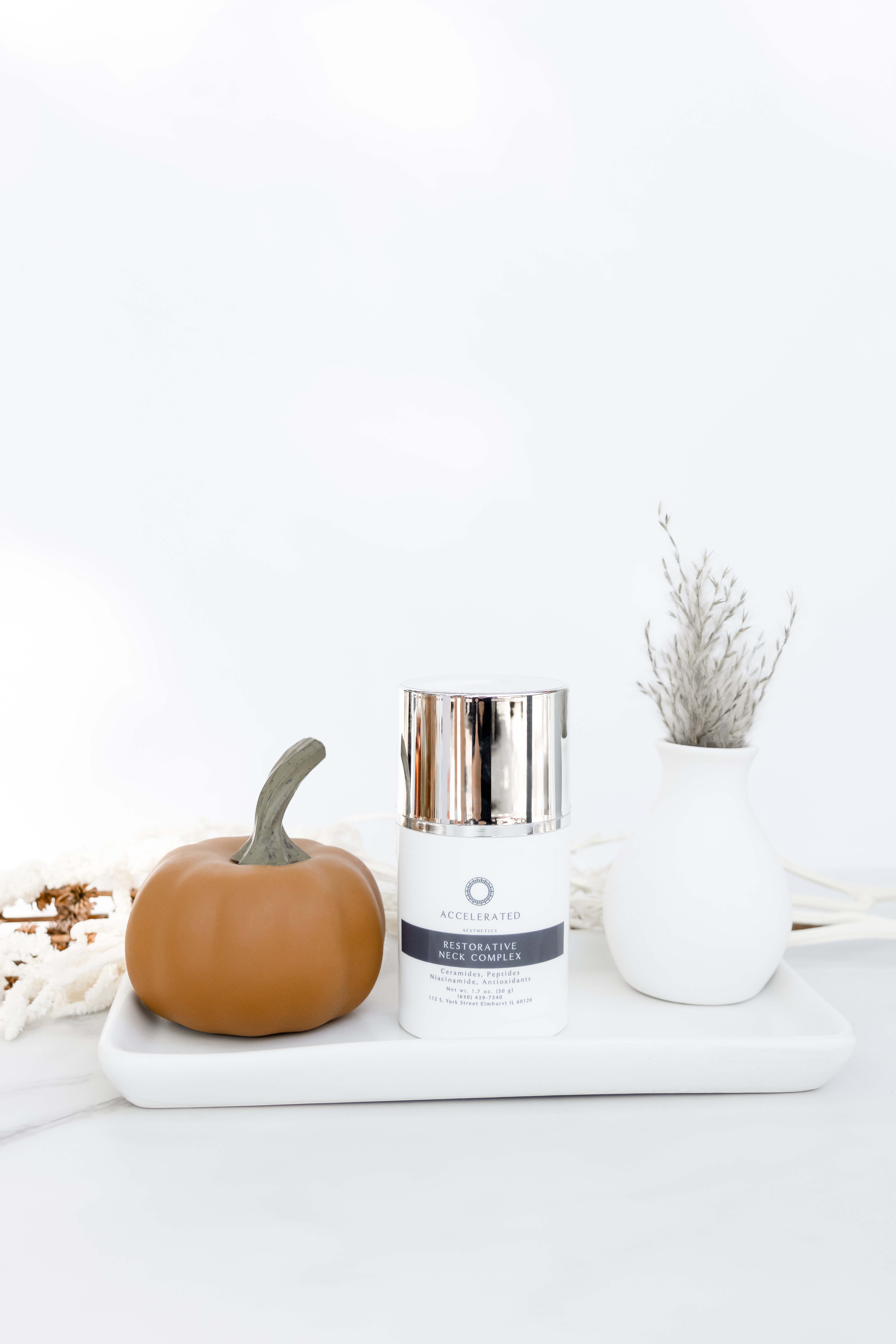 Accelerated Aesthetics skincare jar styled with a small pumpkin for fall, medspa in Elmhurst, IL